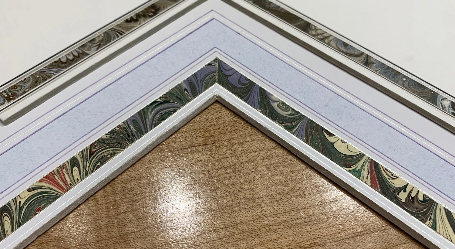 Layered mat corner with silver fillet, drawn lines and marbleized paper border
