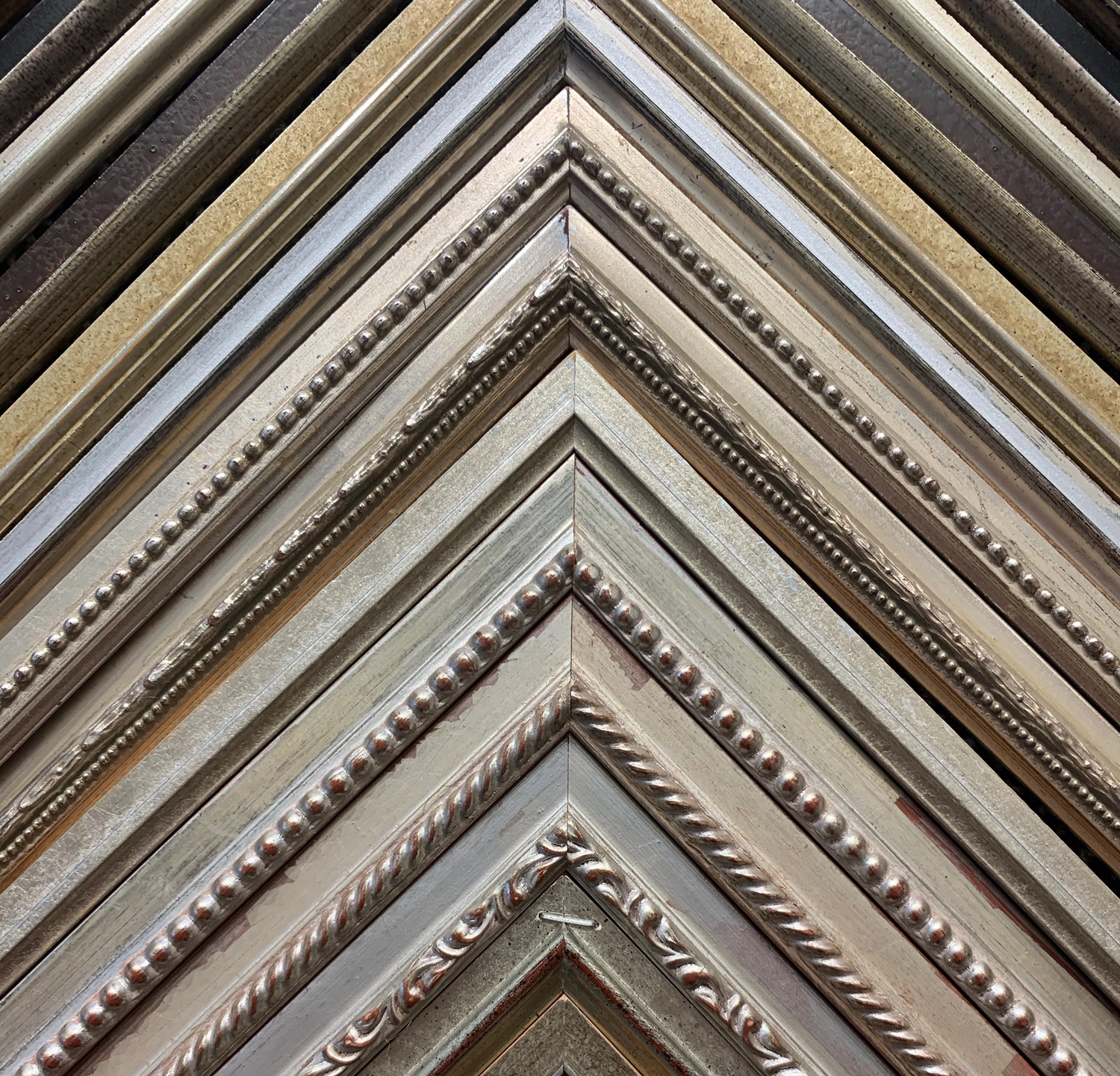 A fan of hand-finished silver picture frame moulding corners