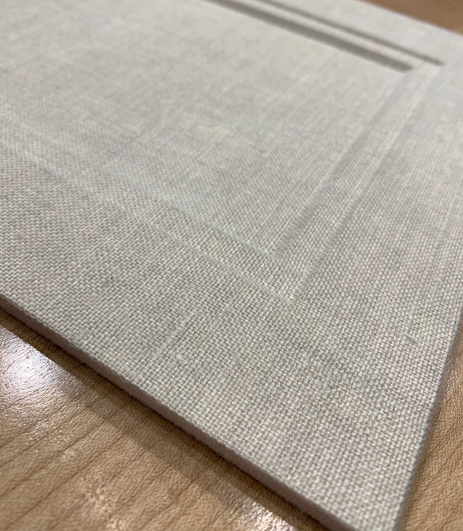 Close-up of a white fabric mat with embossed line detailing